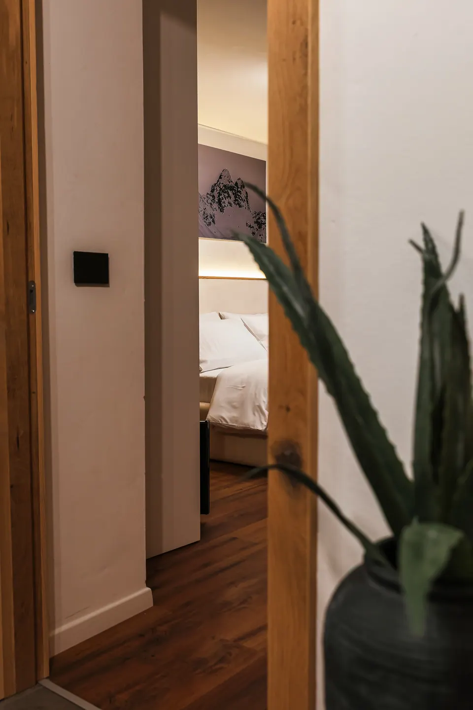 Uno scorcio della camera della Luna dalla porta, con una pianta in primo piano.