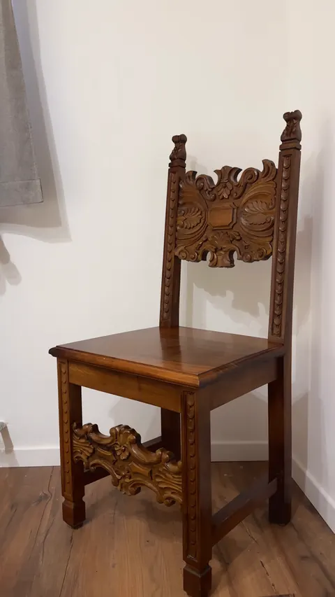 Una sedia di legno con lo schienale e la traversa davanti intagliati, nell'angolo della camera della Luna.